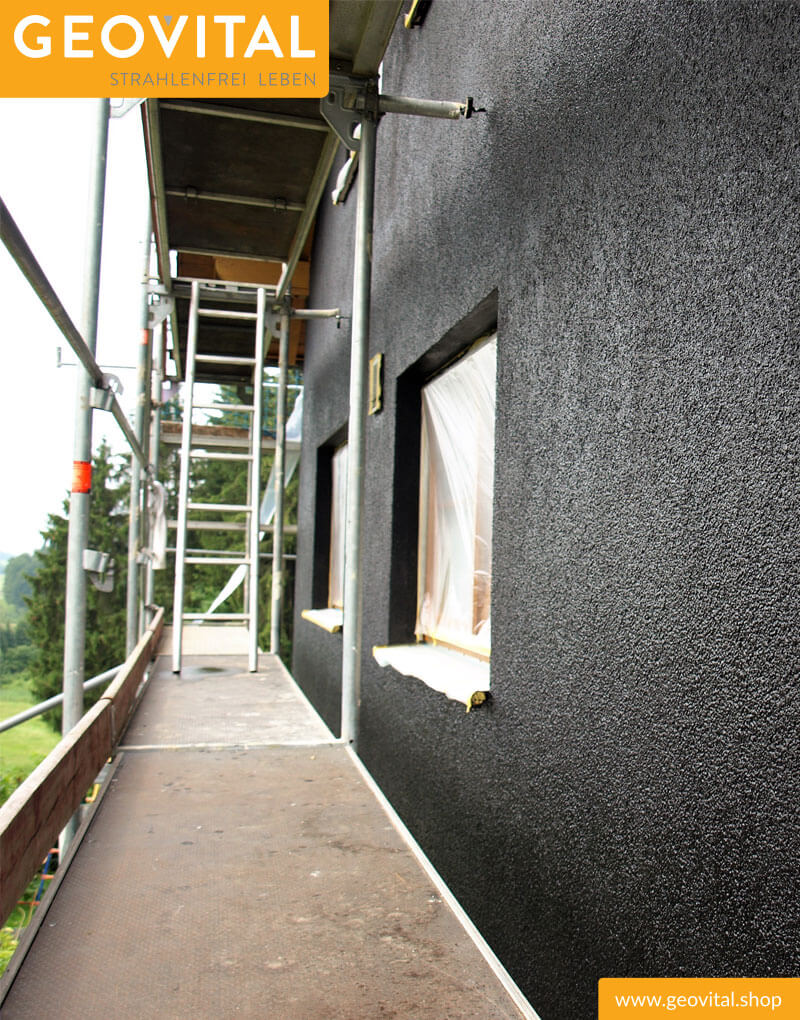 Schwarz gestrichene Außenwand mit Gerüst und T98 Abschirmfarbe