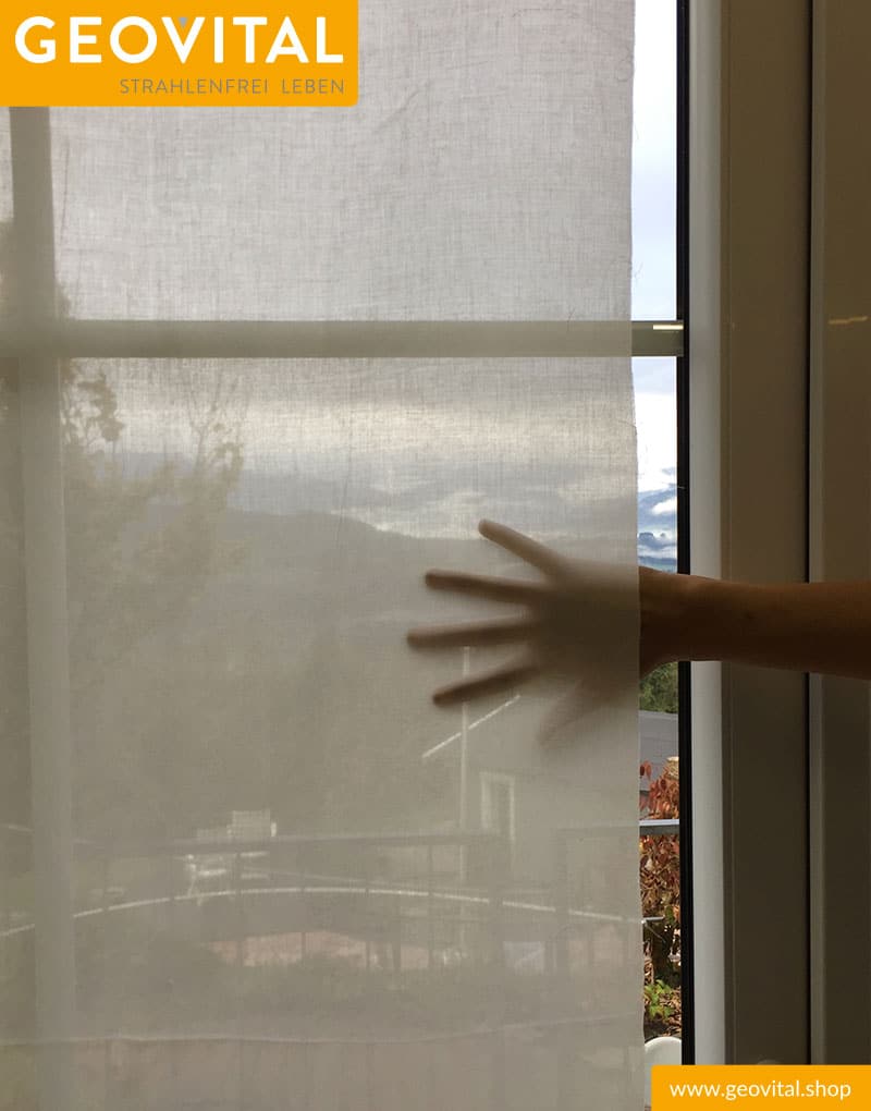 Geovital Abschirmstoff NOVA Baumwolle vor Fenster - Hinter dem Stoff ist eine Hand zu erkennen